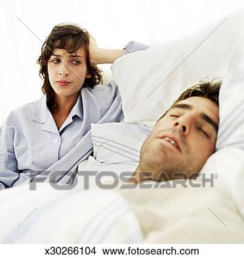 Stock Photo - portrait of a 
young man fast 
asleep while his 
wife glares at 
him. fotosearch 
- search stock 
photos, pictures, 
images, and photo 
clipart