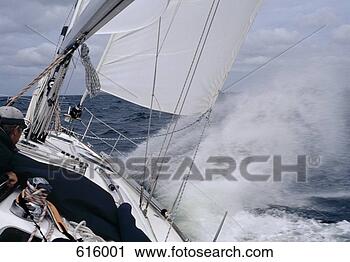 Stock Photography - a man steering 
a yacht in rough 
weather. fotosearch 
- search stock 
photos, pictures, 
images, and photo 
clipart