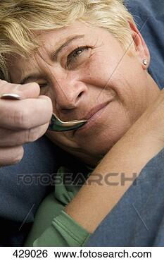 Stock Photo - a woman taking 
medicine from 
a spoon. fotosearch 
- search stock 
photos, pictures, 
images, and photo 
clipart