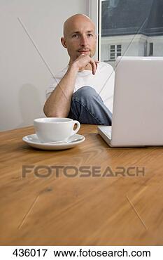 Foto - homem,  sentando, 
 tabela,  laptop, 
 bebida. fotosearch 
- busca de fotos, 
imagens e clipart