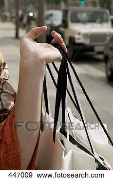 Stock Photograph - a woman holding 
shopping bags 
on a sidewalk, 
 california,  
city of. fotosearch 
- search stock 
photos, pictures, 
images, and photo 
clipart