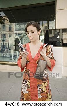 Stock Photo - a woman using 
a mobile phone 
and holding a 
purse,  rodeo 
drive,  los. fotosearch 
- search stock 
photos, pictures, 
images, and photo 
clipart