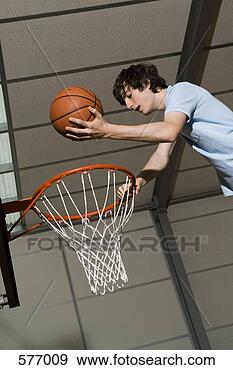 Arquivo Fotográficos - jovem,  ficar, 
 acima,  basquetebol, 
 aro,  segurando, 
 bola. fotosearch 
- busca de fotos, 
imagens e clipart