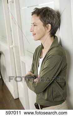 Arquivo de Fotografia - sorrindo,  maduras, 
 mulher,  inclinar-se, 
 contra,  parede, 
 braços. fotosearch 
- busca de fotos, 
imagens e clipart