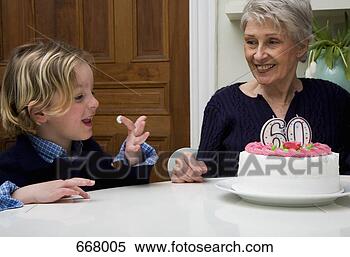 Banco de Imagem - sênior,  woman’s, 
 neto,  comer, 
 icing,  aniversário, 
 bolo. fotosearch 
- busca de fotos, 
imagens e clipart