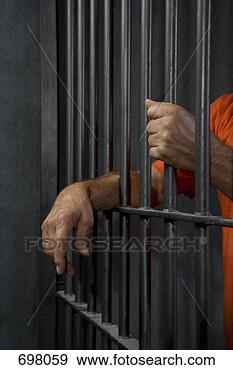 Stock Photograph - a prisoner standing 
behind his prison 
cell bars. fotosearch 
- search stock 
photos, pictures, 
images, and photo 
clipart