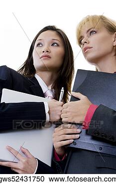 Stock Photography - low angle view 
of two businesswomen 
holding a laptop 
and a file. fotosearch 
- search stock 
photos, pictures, 
images, and photo 
clipart