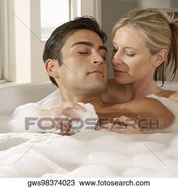 Stock Photo - close-up of a 
young woman scrubbing 
a young man's 
chest with a bath. 
fotosearch - search 
stock photos, 
pictures, images, 
and photo clipart