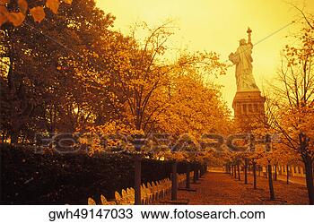 Stock Photo - trees in front 
of a statue,  
statue of liberty, 
 new york city, 
 new. fotosearch 
- search stock 
photos, pictures, 
images, and photo 
clipart