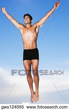 Stock Image - low angle view 
of a young man 
jumping in air. 
fotosearch - search 
stock photos, 
pictures, images, 
and photo clipart