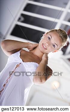 Stock Photo - low angle view 
of a young woman 
with her hand 
on her neck. fotosearch 
- search stock 
photos, pictures, 
images, and photo 
clipart
