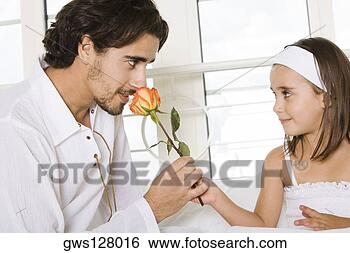 Stock Photo - close-up of a 
father sitting 
with his daughter 
smelling a rose. 
fotosearch - search 
stock photos, 
pictures, images, 
and photo clipart