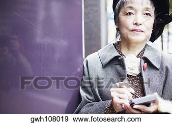 Stock Photograph - close-up of a 
mature woman holding 
a personal data 
assistant. fotosearch 
- search stock 
photos, pictures, 
images, and photo 
clipart