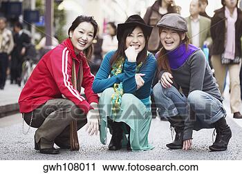 Stock Photography - portrait of three 
young women squatting 
on the street. 
fotosearch - search 
stock photos, 
pictures, images, 
and photo clipart