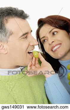 Stock Photography - close-up of a 
mid adult woman 
feeding a grape 
to a mid adult 
man. fotosearch 
- search stock 
photos, pictures, 
images, and photo 
clipart