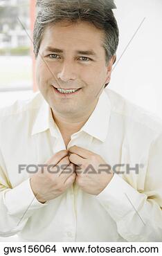 Stock Photo - portrait of a 
mature man buttoning 
his shirt and 
smiling. fotosearch 
- search stock 
photos, pictures, 
images, and photo 
clipart