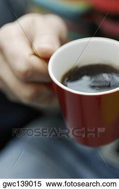 Stock Image - close-up of a 
person's hand 
holding a cup 
of tea. fotosearch 
- search stock 
photos, pictures, 
images, and photo 
clipart