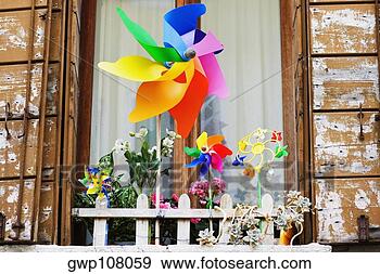 Stock Photograph - low angle view 
of pinwheels in 
front of a window. 
fotosearch - search 
stock photos, 
pictures, images, 
and photo clipart