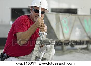 Foto - macho,  construção, 
 trabalhador, 
 aperto,  corda, 
 concreto,  bloco. 
fotosearch - busca 
de fotos, imagens 
e clipart
