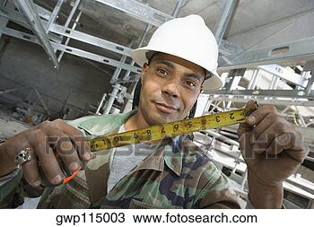 Banco de Imagem - retrato,  macho, 
 construção,  
trabalhador,  
segurando,  fita, 
 medida. fotosearch 
- busca de fotos, 
imagens e clipart
