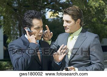 Stock Photo - close-up of a 
businessman talking 
on a hands free 
device with another. 
fotosearch - search 
stock photos, 
pictures, images, 
and photo clipart