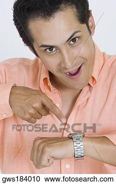 Stock Photography - portrait of a 
young man pointing 
at his wristwatch. 
fotosearch - search 
stock photos, 
pictures, images, 
and photo clipart