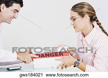 Stock Photography - side profile of 
a businessman 
and a businesswoman 
holding a package. 
fotosearch - search 
stock photos, 
pictures, images, 
and photo clipart