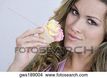 Banco de Imagem - retrato,  jovem, 
 mulher,  comer, 
 cupcake. fotosearch 
- busca de fotos, 
imagens e clipart