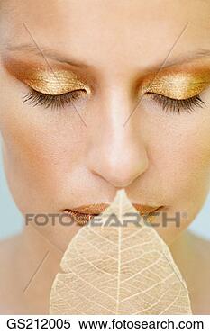 Stock Image - lady's face with 
golden make up 
and a skeletal 
leaf at her lips. 
fotosearch - search 
stock photos, 
pictures, images, 
and photo clipart
