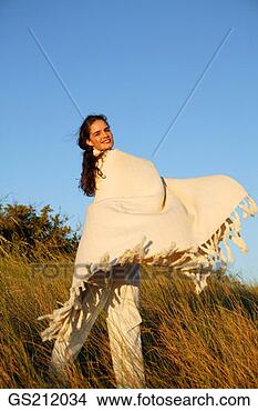 Stock Photo - lady standing 
in tall grasses 
swinging a blanket 
around herself. 
fotosearch - search 
stock photos, 
pictures, images, 
and photo clipart