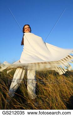 Stock Image - lady standing 
in tall grasses 
swinging a blanket 
around herself. 
fotosearch - search 
stock photos, 
pictures, images, 
and photo clipart