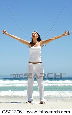 Stock Photography - dark-haired woman 
with outstretched 
arms on a beach. 
fotosearch - search 
stock photos, 
pictures, images, 
and photo clipart