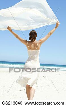 Arquivo de Fotografias - mulher, praia, 
andar, afastado, 
branca, pedaço, 
chiffon, billowing, 
ar. fotosearch 
- busca de fotos, 
imagens e clipart