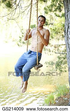 Stock Photograph - man playing on 
a swing. fotosearch 
- search stock 
photos, pictures, 
images, and photo 
clipart