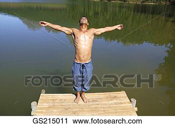 Stock Photography - man on the edge 
of a jetty with 
outstretched arms. 
fotosearch - search 
stock photos, 
pictures, images, 
and photo clipart