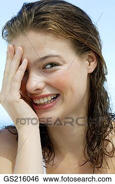 Stock Photo - portrait of a 
dark-haired lady 
covering one eye, 
laughing. fotosearch 
- search stock 
photos, pictures, 
images, and photo 
clipart