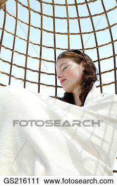 Stock Photography - woman curled up 
in a blanket asleep 
in a wicker seat. 
fotosearch - search 
stock photos, 
pictures, images, 
and photo clipart
