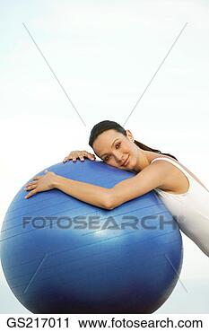 Stock Photography - woman in a bathing 
suit leaning against 
a large ball. 
fotosearch - search 
stock photos, 
pictures, images, 
and photo clipart