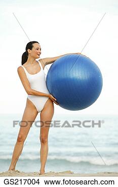 Stock Photo - woman on a beach, 
holding a large 
ball to one side. 
fotosearch - search 
stock photos, 
pictures, images, 
and photo clipart