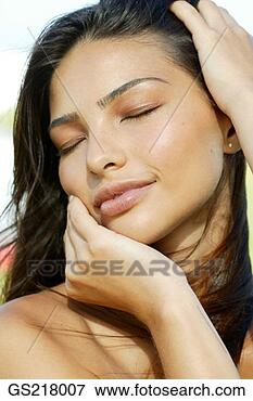 Picture - portrait of a 
dark-haired woman 
with closed eyes 
holding her head 
in. fotosearch 
- search stock 
photos, pictures, 
images, and photo 
clipart