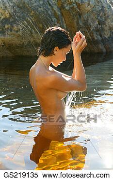 Stock Image - side profile of 
a naked woman 
waist-deep in 
the water with 
raised. fotosearch 
- search stock 
photos, pictures, 
images, and photo 
clipart