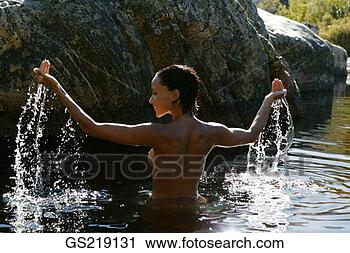 Stock Photography - topless woman 
waist-deep in 
the water with 
outstretched arms. 
fotosearch - search 
stock photos, 
pictures, images, 
and photo clipart