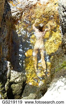 Stock Photograph - woman in the nude 
lying on her front 
in the water. 
fotosearch - search 
stock photos, 
pictures, images, 
and photo clipart