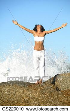 Stock Photography - woman with outstretched 
arms and back 
to a breaking 
wave. fotosearch 
- search stock 
photos, pictures, 
images, and photo 
clipart