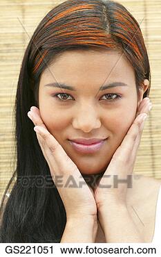 Stock Photography - portrait of a 
smiling dark-haired 
woman with hands 
on cheeks. fotosearch 
- search stock 
photos, pictures, 
images, and photo 
clipart