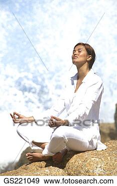 Stock Photograph - woman in meditation 
sitting cross-legged 
at the seafront. 
fotosearch - search 
stock photos, 
pictures, images, 
and photo clipart