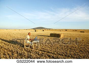 Stock Photo - man sitting at 
his desk in the 
middle of a hay 
field. fotosearch 
- search stock 
photos, pictures, 
images, and photo 
clipart