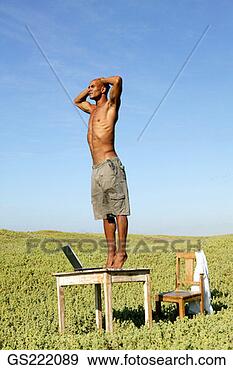 Stock Photograph - man standing on 
his desk in the 
middle of a field. 
fotosearch - search 
stock photos, 
pictures, images, 
and photo clipart