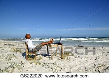 Stock Photography - man taking a break 
from his work 
at his desk on 
the beach. fotosearch 
- search stock 
photos, pictures, 
images, and photo 
clipart