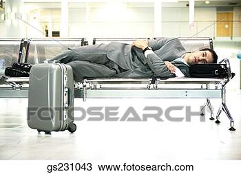 Stock Photo - traveling businessman 
lying down on 
airport bench. 
fotosearch - search 
stock photos, 
pictures, images, 
and photo clipart